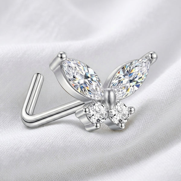 Clou en L argente papillon zircon — pose sur tissu blanc