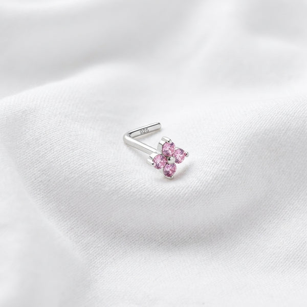 Clou en L argente fleur 4 petales zircons roses — pose tissu blanc