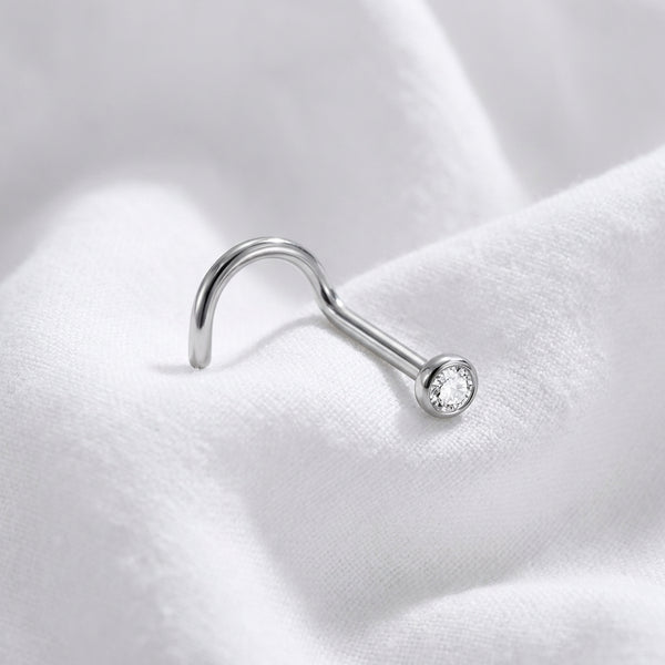 Vis nez argentee zircon rond sertissage bezel — macro pose tissu blanc