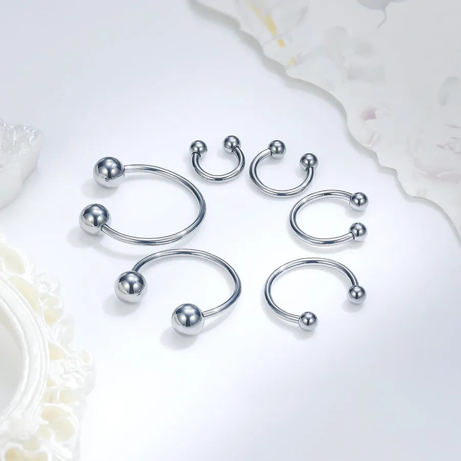 Collection fers a cheval septum argentes 6 tailles differentes — flat lay fond blanc