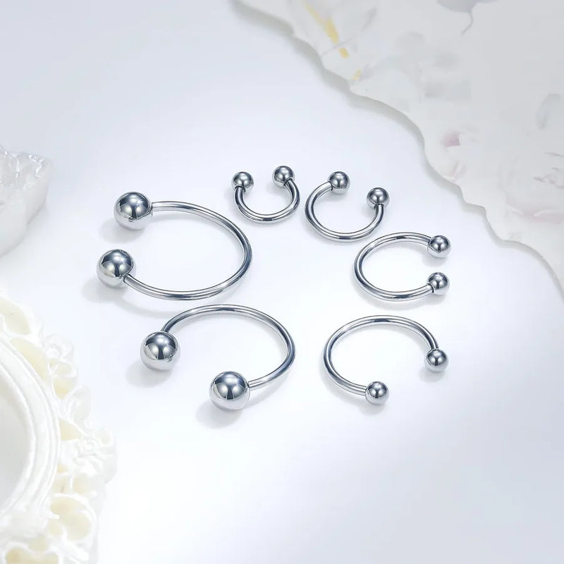 Collection fers a cheval septum argentes 6 tailles differentes — flat lay fond blanc