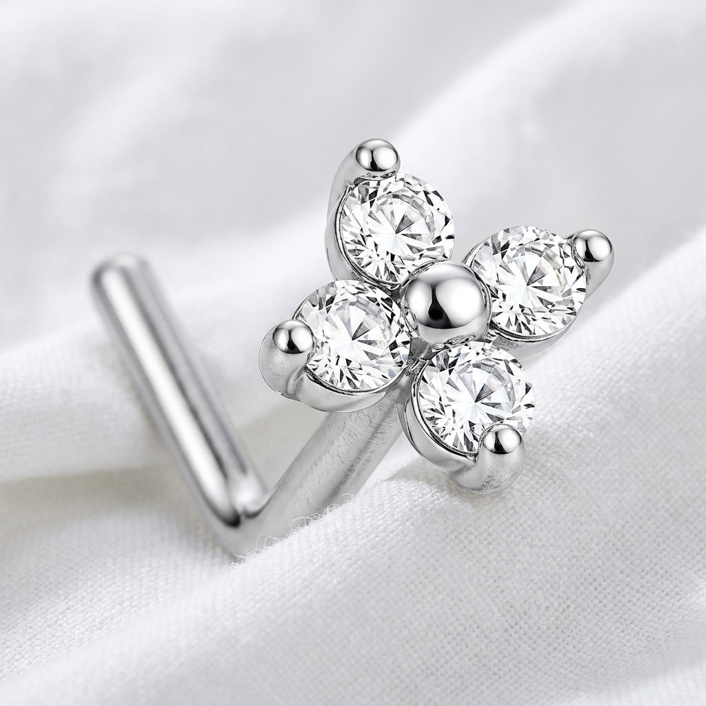 Clou en L argente fleur 4 petales zircons macro — pose sur tissu blanc