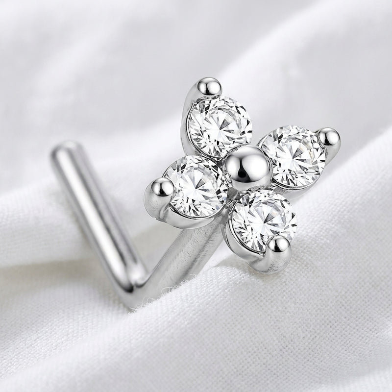 Clou en L argente fleur 4 petales zircons macro — pose sur tissu blanc