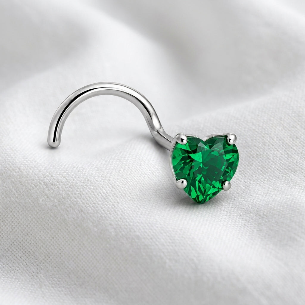 Vis nez argentee zircon coeur vert emeraude — posee sur tissu blanc