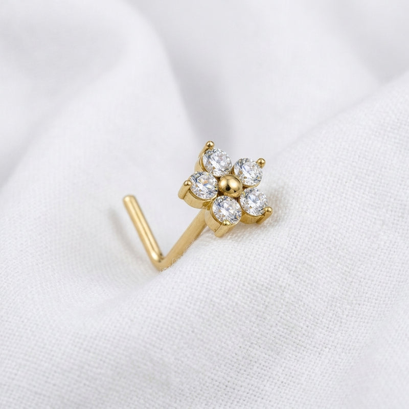 Clou en L dore fleur 4 petales zircons ronds — pose tissu blanc