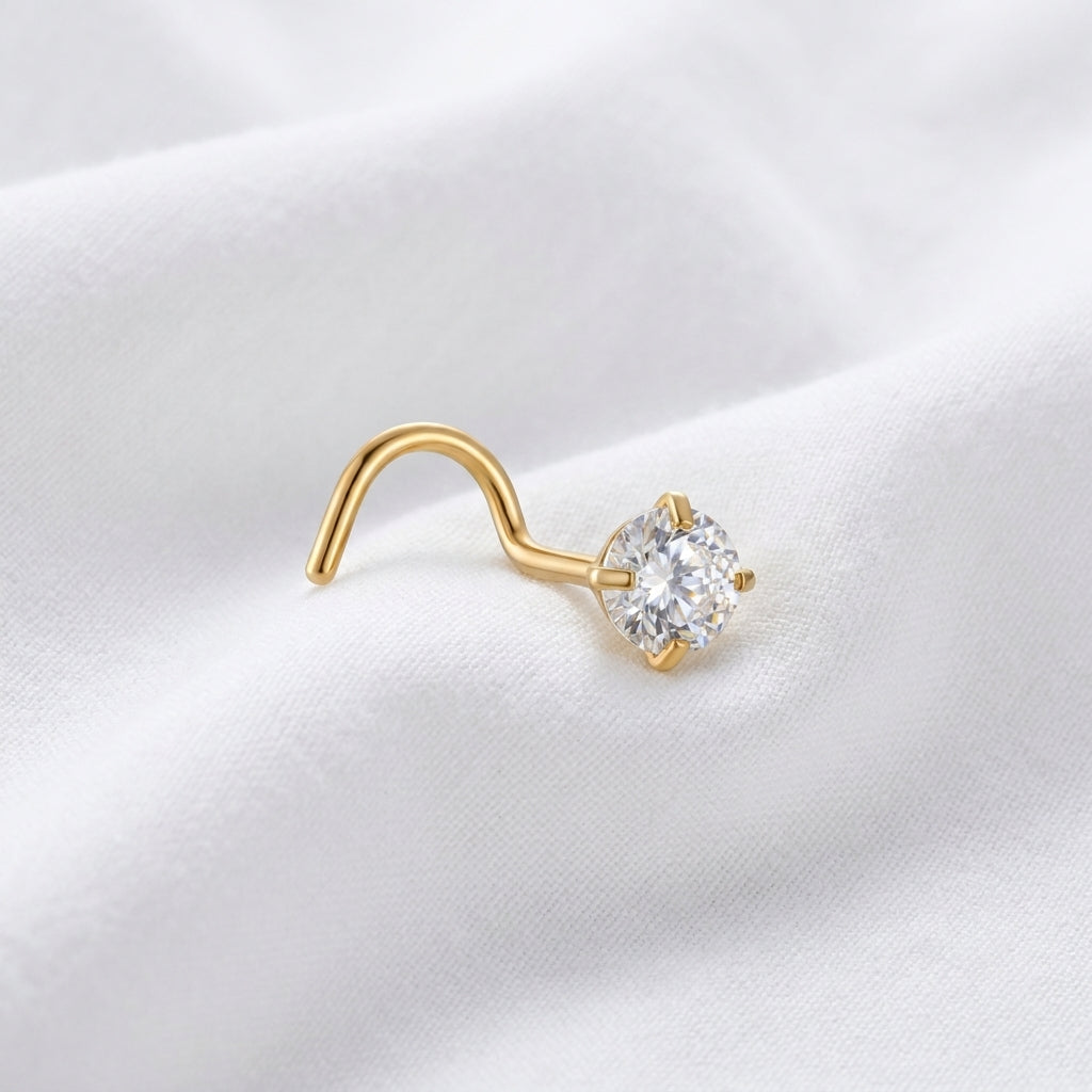 Vis nez doree solitaire zircon brillant — posee sur tissu blanc