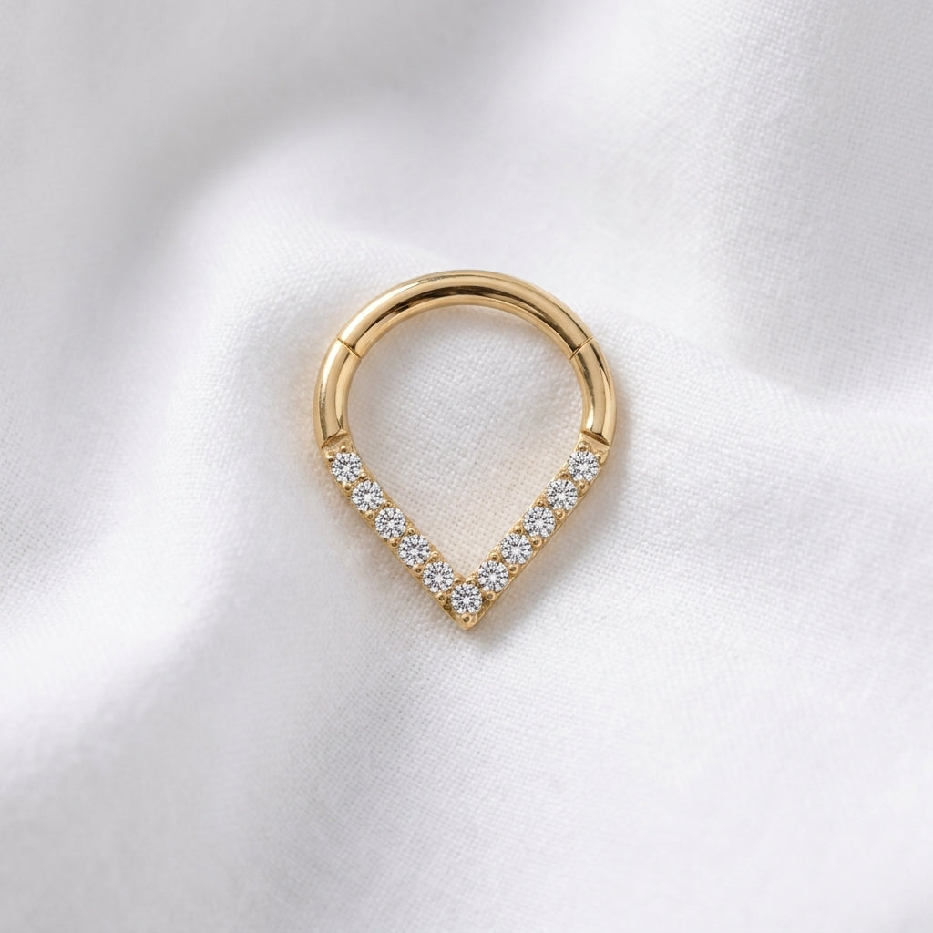 Anneau clicker dore forme poire base V zircons — pose tissu blanc