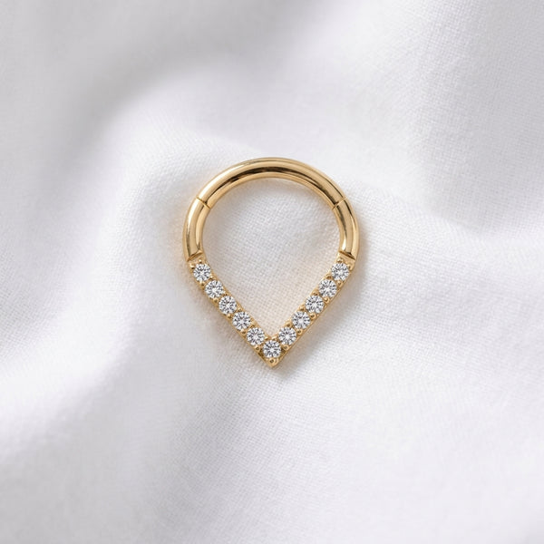Anneau clicker dore forme poire base V zircons — pose tissu blanc