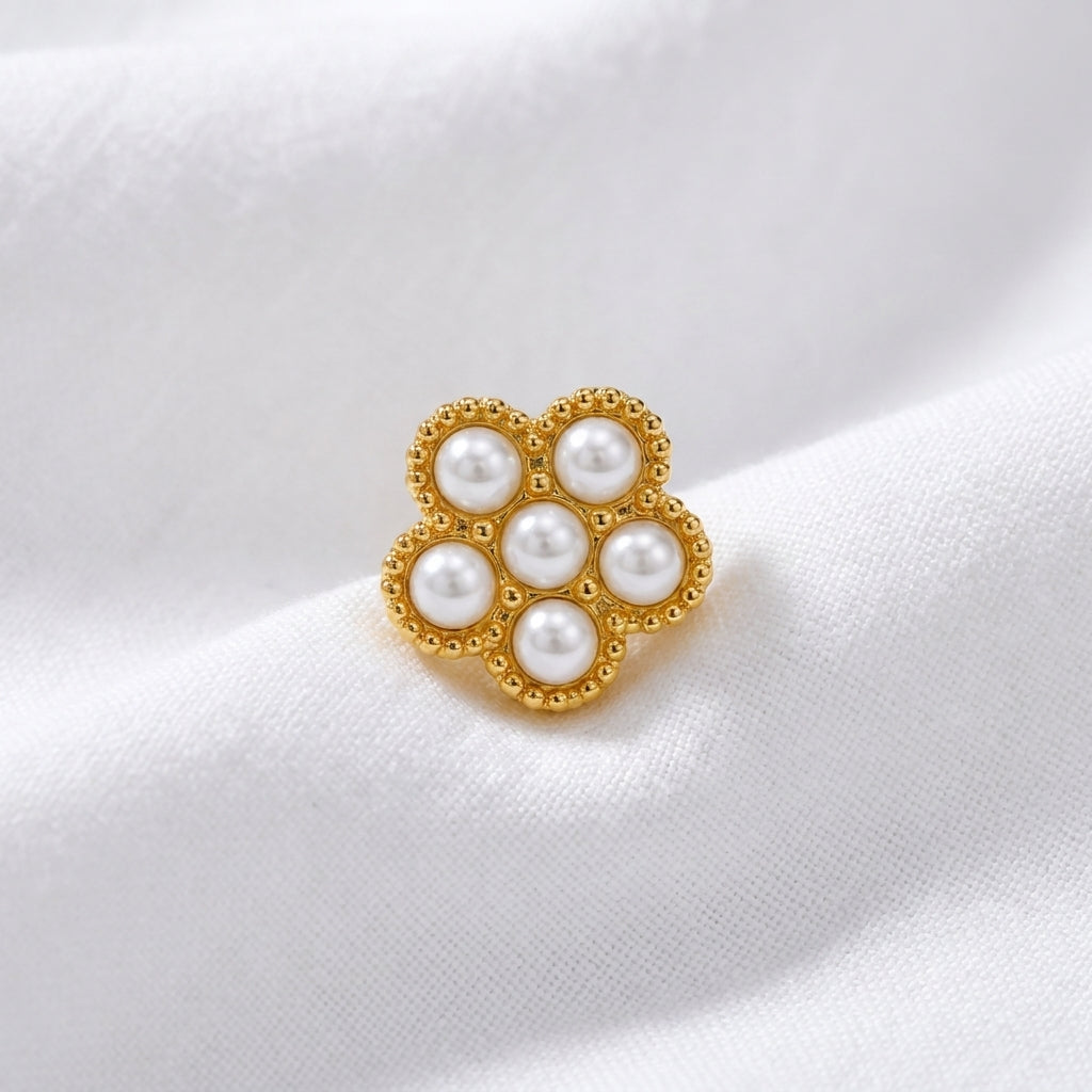 Tete fleur 7 micro-perles blanches monture milgrain doree — macro pose tissu blanc