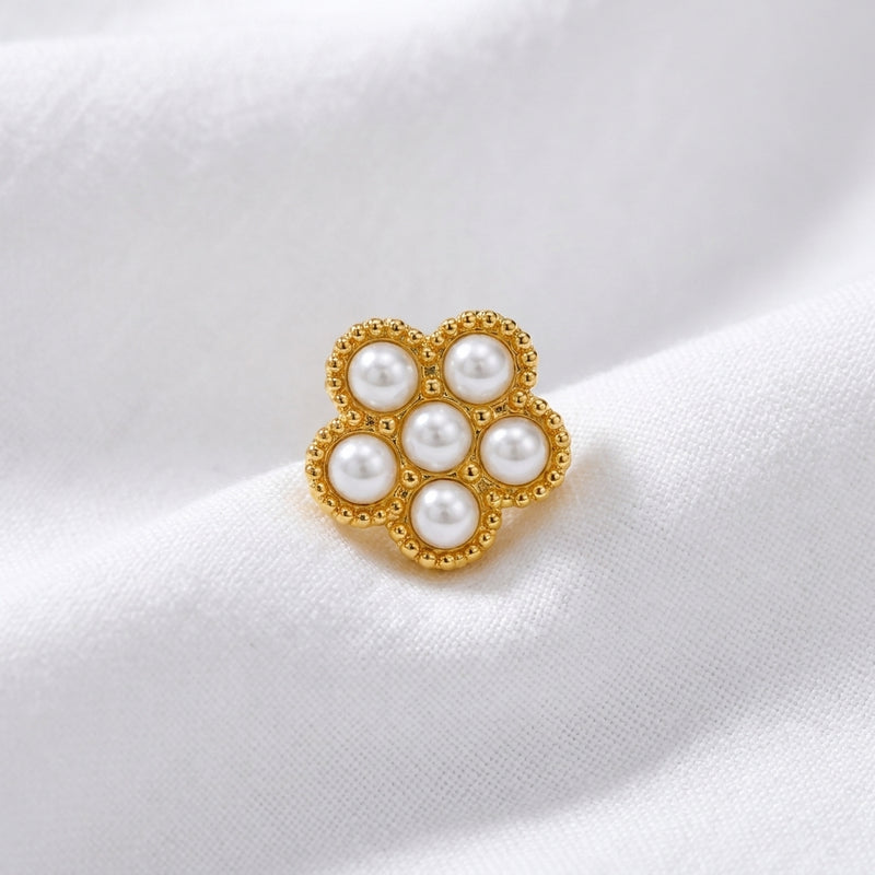 Tete fleur 7 micro-perles blanches monture milgrain doree — macro pose tissu blanc