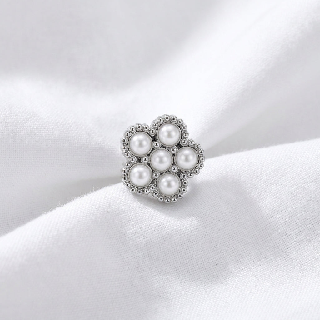 Tete fleur 7 micro-perles blanches monture milgrain argentee — macro pose tissu blanc