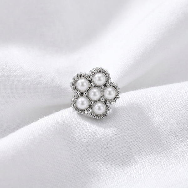 Tete fleur 7 micro-perles blanches monture milgrain argentee — macro pose tissu blanc