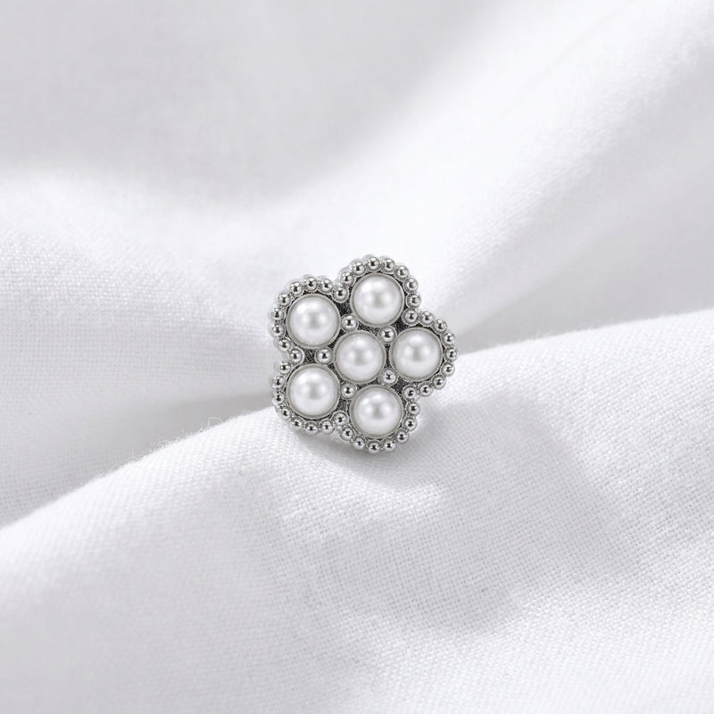 Tete fleur 7 micro-perles blanches monture milgrain argentee — macro pose tissu blanc
