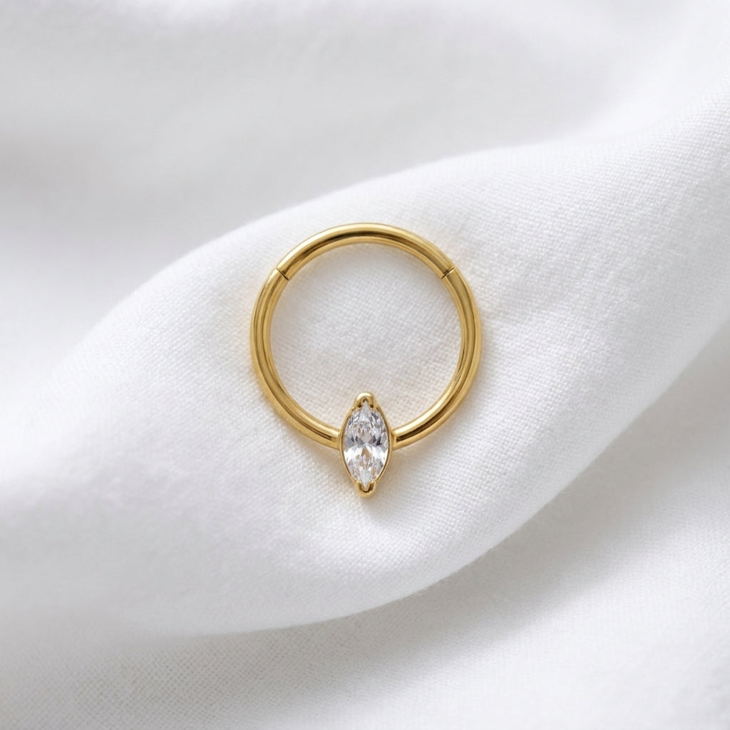 Anneau clicker dore zircon marquise solitaire — pose tissu blanc