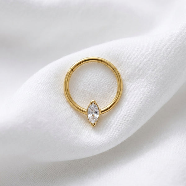 Anneau clicker dore zircon marquise solitaire — pose tissu blanc