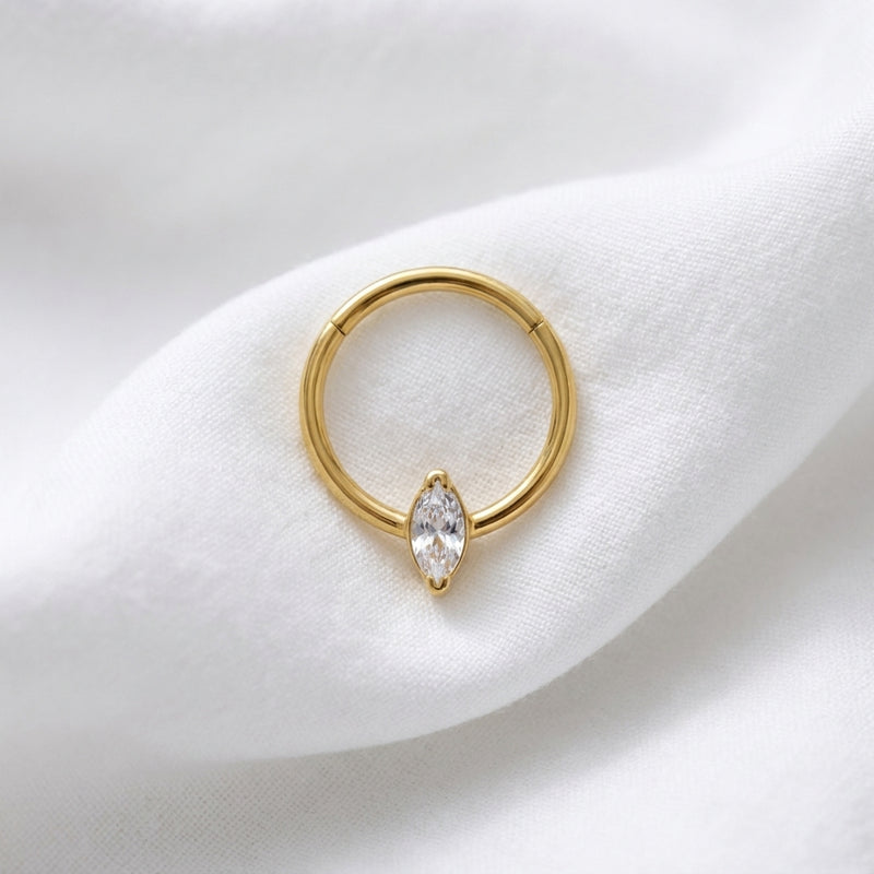 Anneau clicker dore zircon marquise solitaire — pose tissu blanc