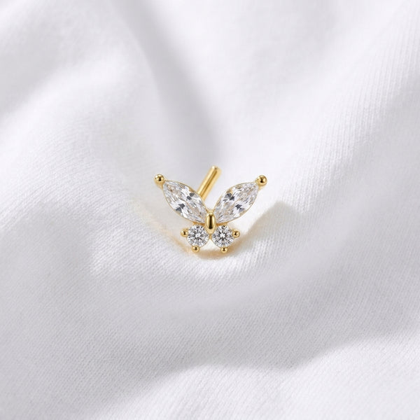 Clou en L dore papillon zircon marquise — pose sur tissu blanc