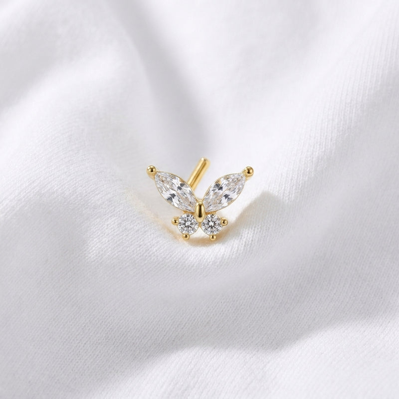 Clou en L dore papillon zircon marquise — pose sur tissu blanc