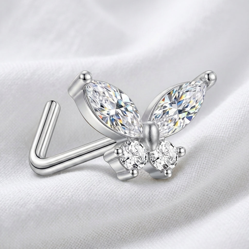 Clou en L argente papillon zircon — pose sur tissu blanc