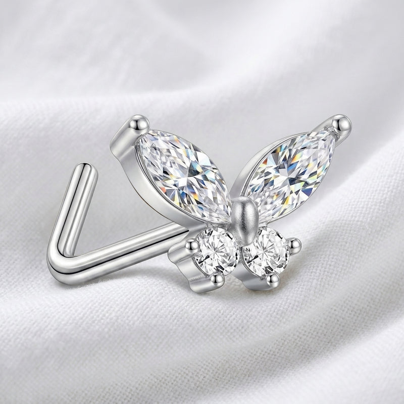 Clou en L argente papillon zircon — pose sur tissu blanc