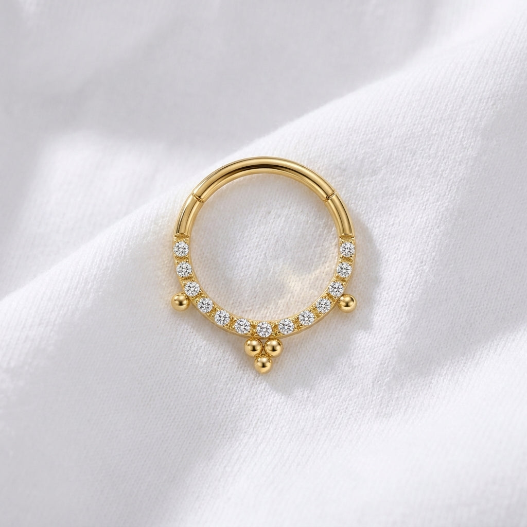 Anneau clicker dore pave zircons 3 pendentifs boules — pose tissu blanc