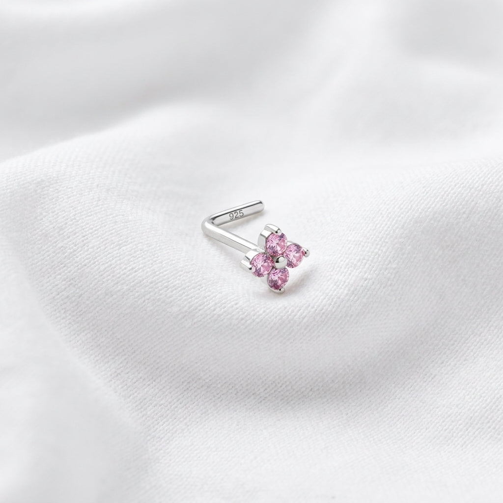 Clou en L argente fleur 4 petales zircons roses — pose tissu blanc
