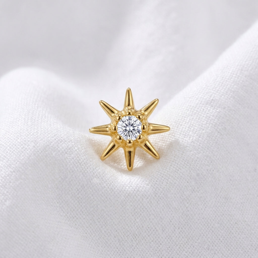Tete etoile polaire 8 branches zircon doree — macro pose tissu blanc