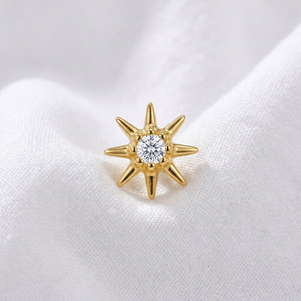 Tete etoile polaire 8 branches zircon doree — macro pose tissu blanc