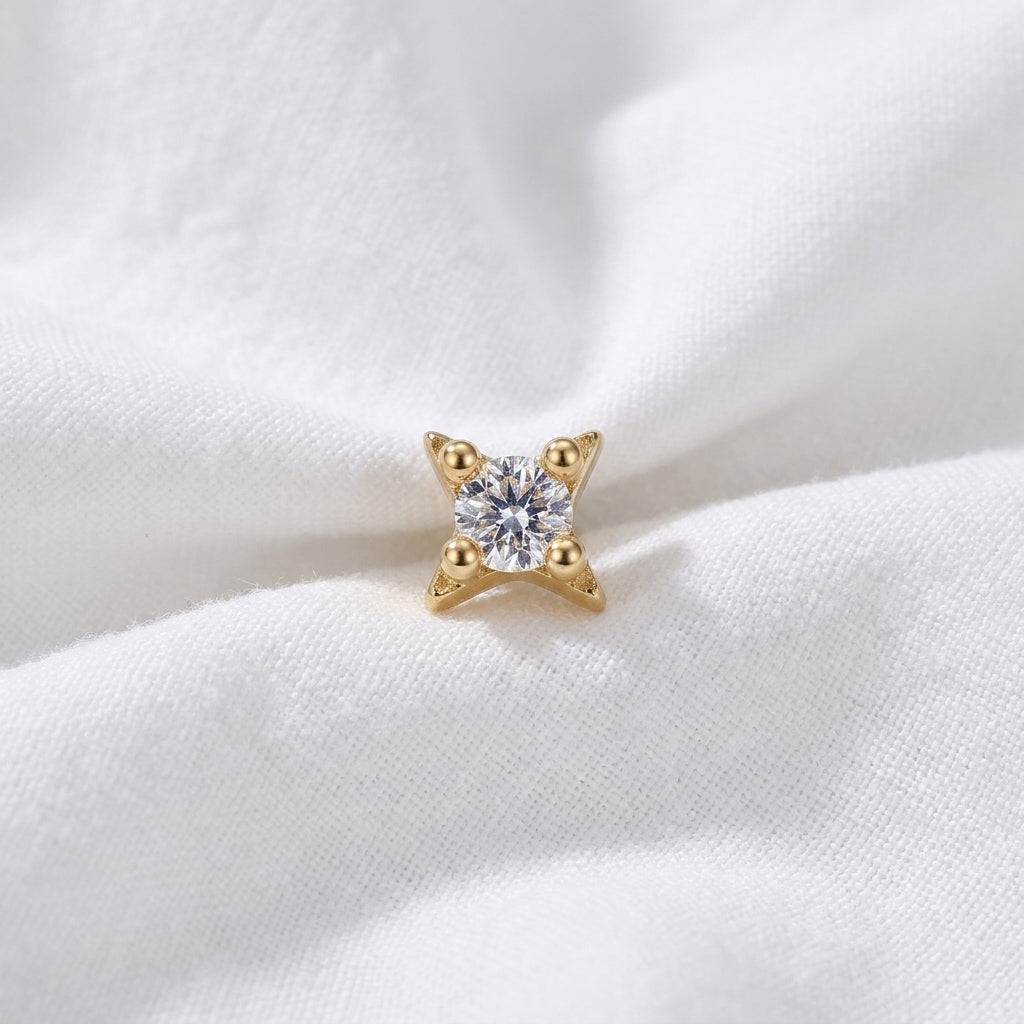 Tete etoile 4 branches boules zircon doree — macro pose tissu blanc