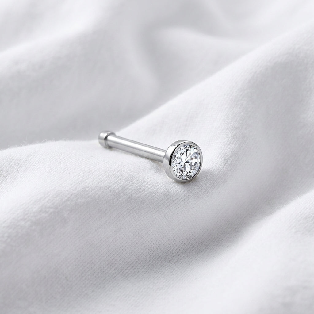 Tige droite nez argentee zircon bezel — posee sur tissu blanc