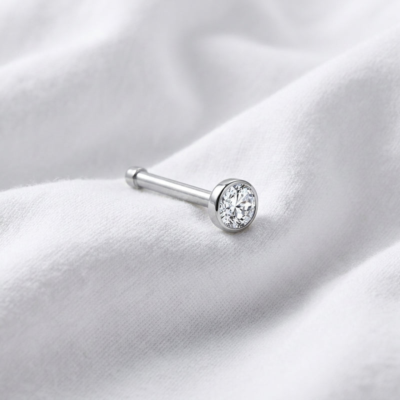 Tige droite nez argentee zircon bezel — posee sur tissu blanc