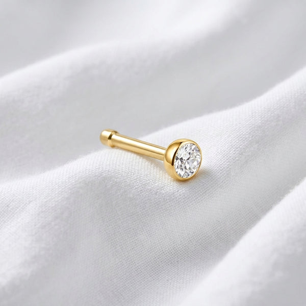 Tige droite nez doree zircon bezel — posee sur tissu blanc