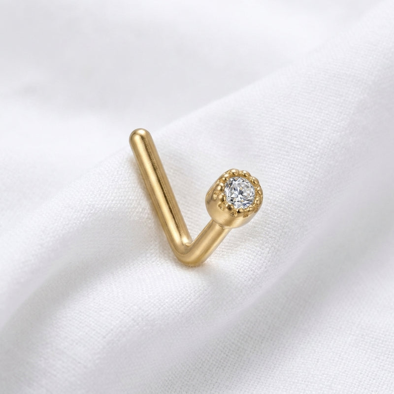 Clou en L dore zircon blanc bezel milgrain — pose tissu blanc