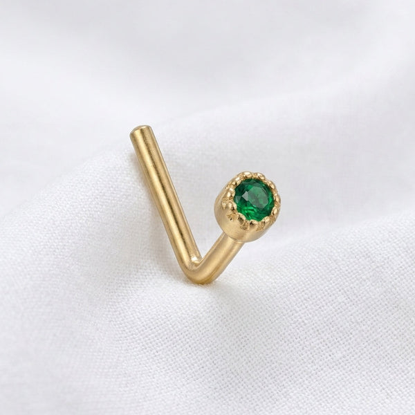Clou en L dore zircon vert emeraude bezel milgrain — pose tissu blanc