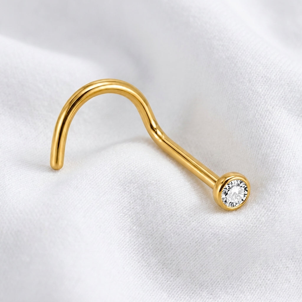 Vis nez doree zircon rond sertissage bezel tige visible — macro pose tissu blanc
